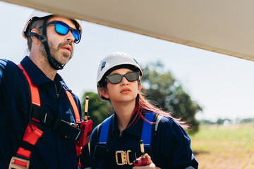 Professional wind turbine engineers preparing and inspecting equipment for installation and maintenance at a renewable energy site, teamwork, clean power, and sustainable technology.