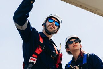 Professional wind turbine engineers preparing and inspecting equipment for installation and maintenance at a renewable energy site, teamwork, clean power, and sustainable technology.