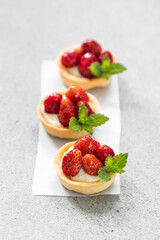 Mini Vegan dessert. Mini Vegan Wild Strawberry tartlets. Light background. Close up