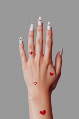 Red Heart Designs on White Nails and Skin Show Creativity in Hand Art and Nail Art
