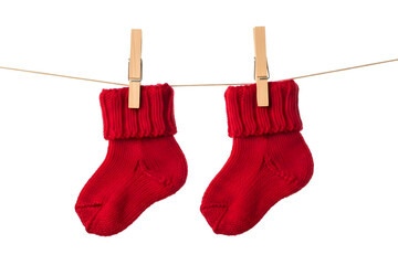 A pair of tiny red knitted baby socks hanging on a clothesline with wooden clothespins isolated on transparent background