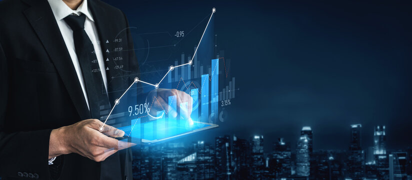 A businessman holds a digital tablet displaying financial graphs in a city skyline at night. The scene combines modernity, technology, and corporate finance, symbolizing growth and success. Scalp - Powered by Adobe