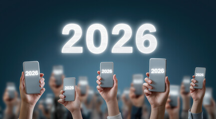 Hands hold smartphones displaying 2026 against dark backdrop.