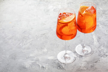 Glasses of refreshing spritzer cocktail on grey textured table. Space for text
