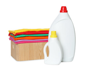 Laundry basket with clean clothes and bottles of detergents isolated on white