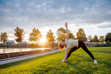Young woman doing yoga exercises in the park