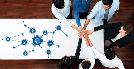 A diverse group of professionals collaborates during a business meeting, fostering creativity and strategic planning around modern technology concepts and visuals. Amity © InfiniteFlow