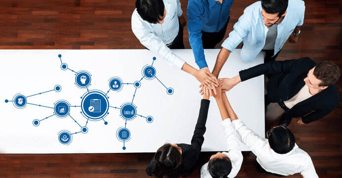 A diverse group of professionals collaborates during a business meeting, fostering creativity and strategic planning around modern technology concepts and visuals. Amity