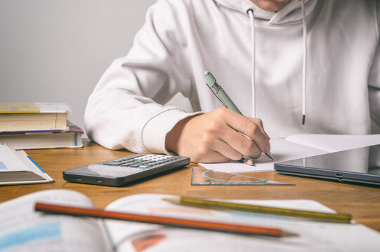 Sch&uuml;ler oder Student schreibt an Schreibtisch &ndash; Symbol f&uuml;r Lernen, Studium und akademische Arbeit