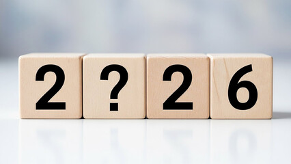 A close-up of wooden blocks with numbers and a question mark on a white surface