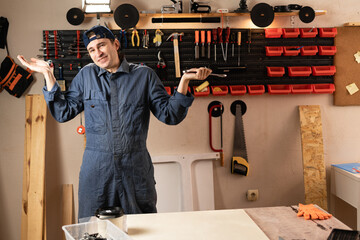 young carpenter say I don't know while to assemble furniture working in studio or workshop with tools on walls. woodworking workshop