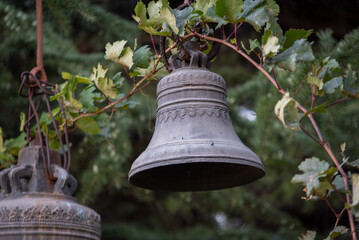 Antique Church Bell Among Green Leaves