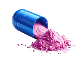 A blue capsule spills pink powder against a black background