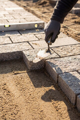 Professional Paver Worker Laying Paving Stones for Pathway Construction