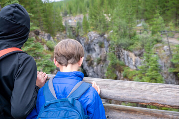 Two boys looking over the edge of a bridge into the Maligne Canyon in Jasper National Park, Alberta, Canada