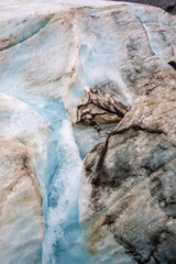 Crevasse in the ice from melting at Athabasca Glacier in Jasper National Park with cloudy sky