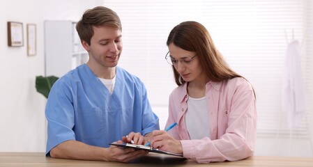 Obraz premium Medical assistant helping patient at reception in clinic
