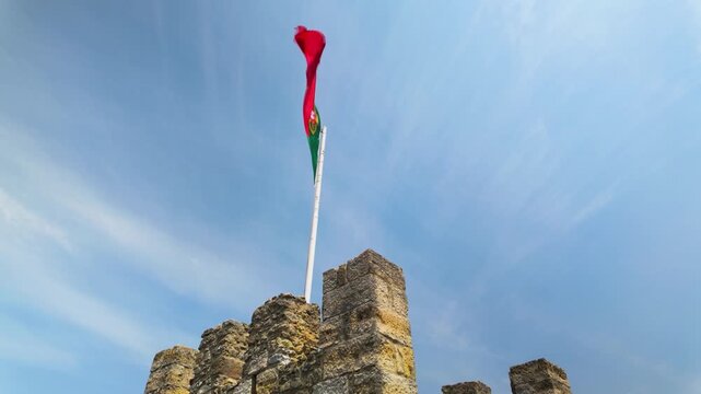 Portuguese flag waving on a castle tower.
