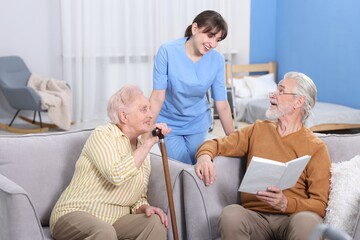 Fototapeta premium Senior man, woman and care worker discussing book at retirement home