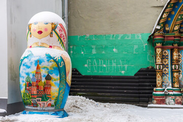 Fototapeta premium Moscow, Russia, 29 December 2025, A giant decorative Matryoshka nesting doll statue painted with St. Basil's Cathedral standing outdoors in the snow. A street decoration