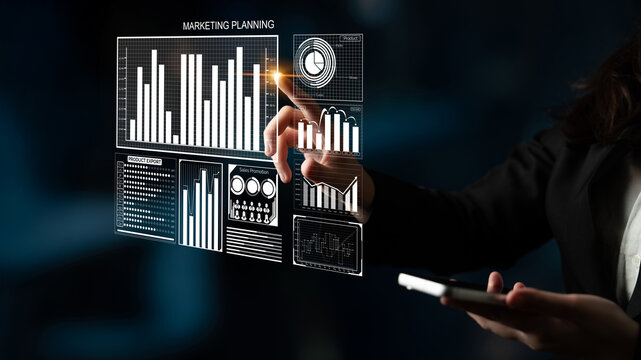 A businesswoman engages with a digital interface showcasing marketing planning and data visualization. The modern office environment enhances the professional atmosphere. Impute - Powered by Adobe