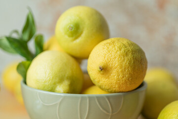 Fresh whole lemon in ceramic bowl with leaf detail, soft natural light and blurred background. Suitable for food advertising, packaging mockups, ingredient presentation and retail visuals.