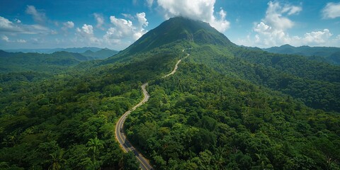 Aerial panorama of winding road encircling lush mountain