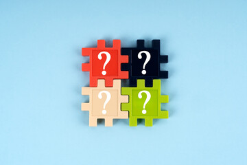 Jigsaw puzzle with four question marks on blue background