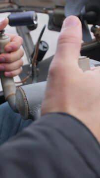 Vertical video. Close up. Male hands of the pilot take the steering wheel of the plane. Vintage style. The old historical cabin Soviet AN-2.