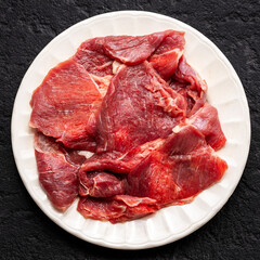 Raw Beef Meat Slices on White Plate, Top View