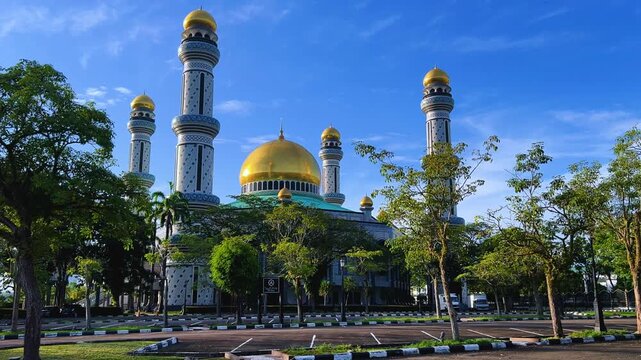 The golden dome and building of the Jamil Asra Hassan Al-Bolkiah Mosque in Bandar Seri Bagawan, Brunei Darussalam, are framed by tropical palm trees on a sunny day. Asia. 4К