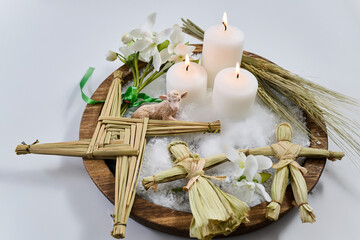 Imbolc altar with brigid's cross, dolls, candles, and lamb