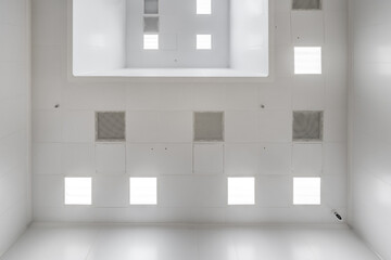 view straight up at cassette suspended ceiling with square fluorescent lights or halogen spots lamps  in a work area or hallway with ventilation