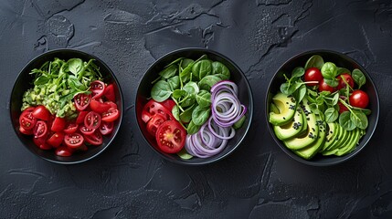 Artful flat lay of three avocado salad variations in matte black bowls with textured background