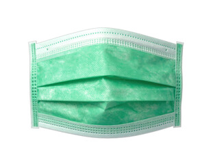 Close-up of disposable, light-green medical face mask, isolated against a black background