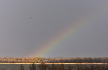 Rainbow in the sky over the river. Winter landscape 