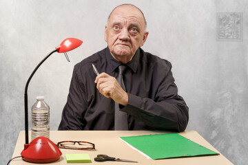 portrait homme âgé assis à son humble bureau