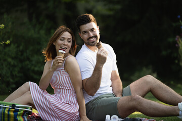 Boyfriend and girfriend enjoying ice cream on picnic