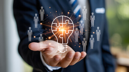 Innovation and teamwork concept with businessman holding glowing puzzle lightbulb representing creative solutions and collaboration.
