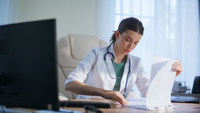 Serious therapist examining diagnosis papers office closeup. Doctor check scan