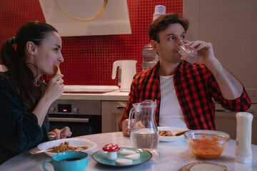 Young couple eating together in home kitchen, casual domestic lifestyle, everyday routine and...