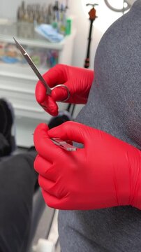 Close-up of a surgeon's hands in disposable gloves choosing an instrument for work and starting an operation. No face. 4k, red komodo