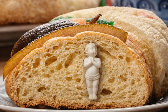 Mu&ntilde;eco de porcelana incrustado en deliciosa Rosca de Reyes.