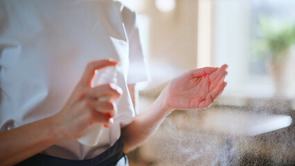 Closeup waitress disinfecting hands applying antibacterial spray at restaurant