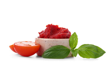 Bowl of tasty tomato paste with basil leaves on white background
