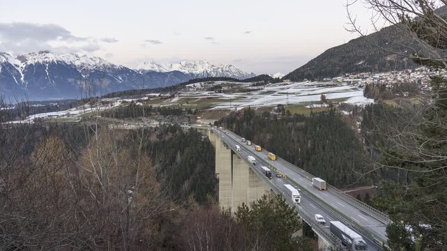 Motorway viaduct in a majestic mountain landscape at dusk in winter. Tyrol, Austria - Time Lapse