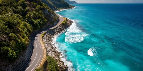 Obraz premium Scenic coastal road winding along a rocky shore with turquoise water.