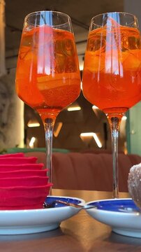 wooden table desserts Coco and Rose jelly cheesecake and two glasses of Aperol