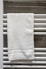 Towel drying on a rack in a bathroom after a shower in a modern home during daylight hours