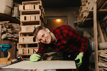 Young male carpenter working on a wooden piece in his workshop